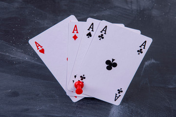 four playing cards all aces on a board