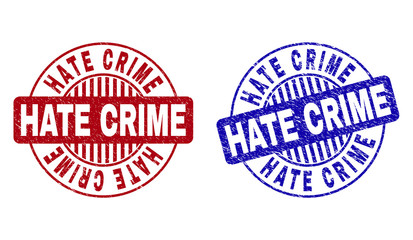 Grunge HATE CRIME round stamp seals isolated on a white background. Round seals with distress texture in red and blue colors. Vector rubber imprint of HATE CRIME tag inside circle form with stripes.