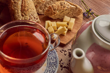 cup of tea and bread on wooden background