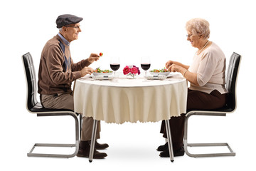 Senior couple eating a salad at a restaurant table