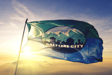 Salt Lake City capital of Utah flag waving on the top sunrise mist fog