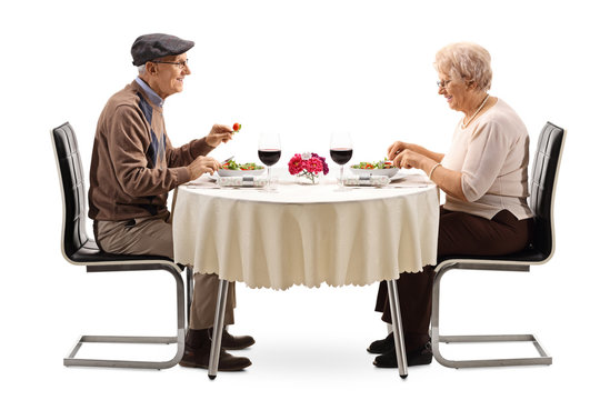 Senior Couple Eating A Salad At A Restaurant Table