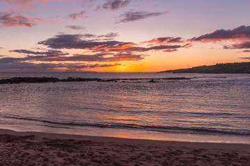 Sunset over ocean near shore and rocks