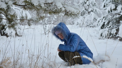 girl in a snowdrift in winter under a tree