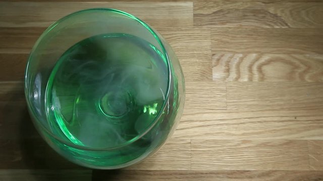 Absinthe glass smoke wooden table hd footage nobody 