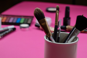 Make up brushes on a hot pink background