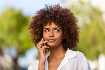 Outdoor portrait of a Young black African American young woman speaking on mobile phone