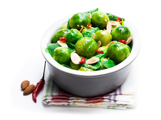 Cooked brussels sprouts with spinach and almonds isolated on white