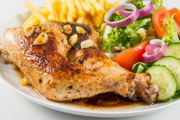Zancas de pollo asado con patatas fritas y ensalada