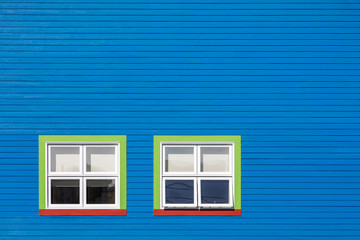 Obraz na płótnie Canvas Green and red windows on blue wall