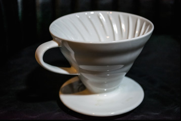 White funnel Pourover on a black background for preparation of coffee by an alternative method. Work the barista in coffee shop. 