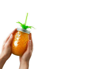 Summer holidays, vacation background. Summer refreshing drink, juice or cocktail. Woman's hand holding pineapple mason jar filled with orange juice, isolated, copy space.