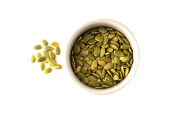 Pumpkin seeds isolated in bowl with copy space. Healthy vegetarian snack. Super food, breakfast or snack.