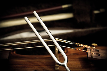 Tuning fork and a violin - obrazy, fototapety, plakaty