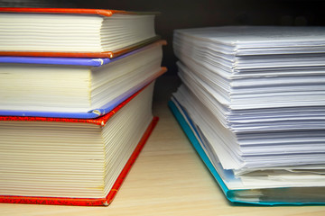 A stack of books and papers on the desktop, symbolizing learning, laws and regulations, a huge amount of information