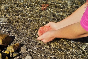 Woman hands on the water