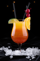Tequila Sunrise cocktail, on a black background