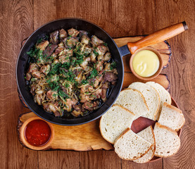 Sliced meat in a frying pan with the liver, heart and onions.