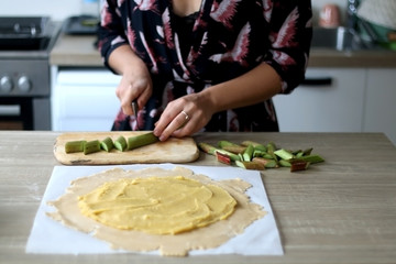 Young woman making rhubarb pie. Selective focus.