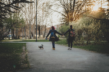 Lesbian couple In Love Walking In urban Area. Followed By Cute Yorkshire Terrier