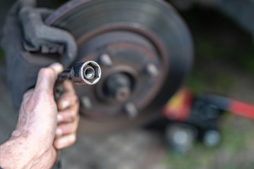 Replacing the wheel in a passenger car. Changing wheels from winter to summer.