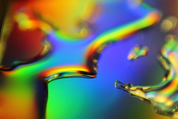 abstract liquid colorful background with water droplets and splash on holographic surface