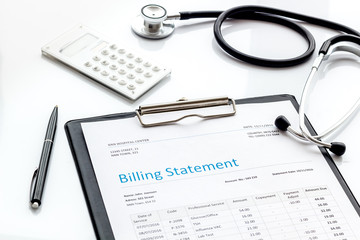 medical treatment bill, calculator and phonendoscope on white background