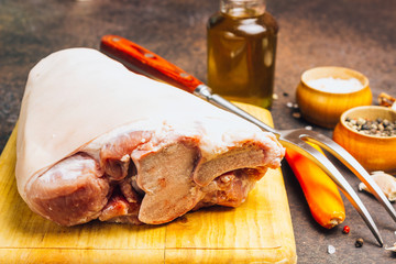 Raw pork knuckle on an cutting board. Rustic style.