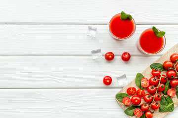 Naklejka na ściany i meble summer cocktails for freshness with red tomato and ice on white background top view copyspace