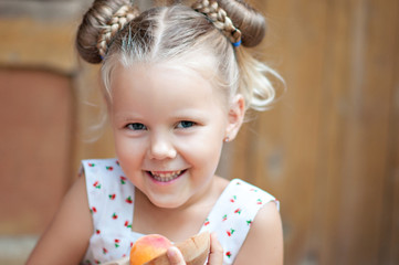 Beautiful girl laughs and has fun near the house in nature. Vacation at the grandmother.