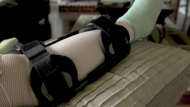tilt showing a man with a leg brace and bandage on the knee