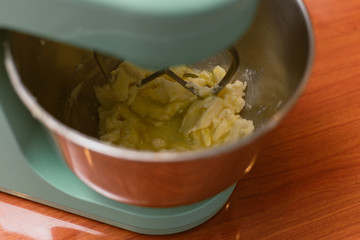 the mixer kneads and kneads the dough of butter, flour and eggs for muffins and biscuits