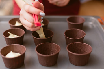 pastry chef makes muffins and pours dough into molds