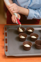 pastry chef makes muffins and pours dough into molds