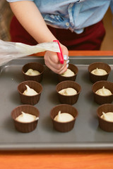 pastry chef makes muffins and pours dough into molds