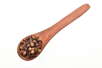 clove buds in wooden spoon isolated on white background