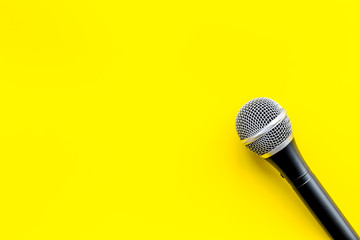 blogger, journalist or musician office desk with microphone on yellow background top view copyspace