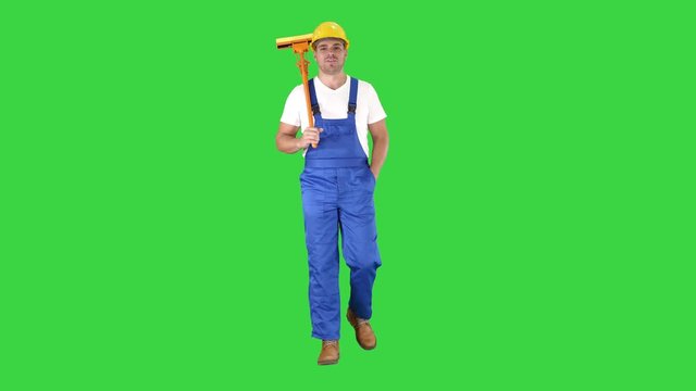 Man with cleaning mop walking and smiling to camera on a Green Screen, Chroma Key.
