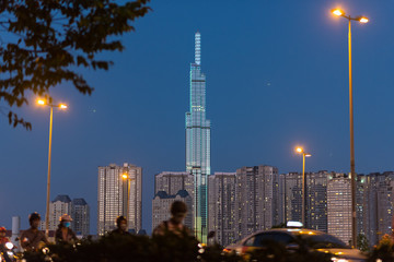 Night skyline of Vinhomes Central Park with Landmark 81 skyscraper with street lights and traffic in the foreground (blurred). Binh Thanh District, Ho Chi Minh City, Vietnam.