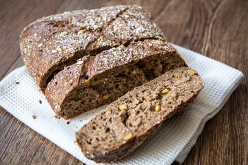 Homemade healthy freshly baked organic whole grain bread with healthy seeds on wooden table