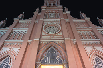 Catholic church towers up in the dark of night. The facade of Da Nang Cathedral (also known as Basilica of the Sacred Heart of Jesus).
