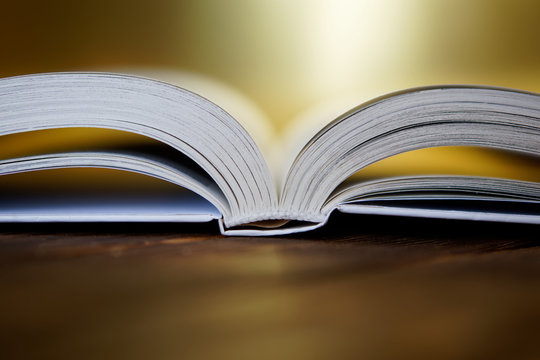 Opened book on a golden background. Close-up
