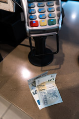 EURO banknotes lying near a payment terminal POS in a cafe