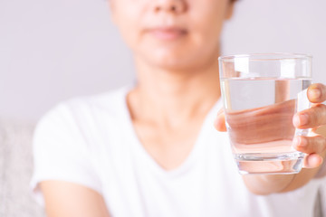 Young woman holding drinking water glass in her hand. Health care concept.