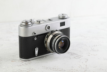 The old 35 mm film rangefinder camera on white cement background.