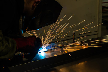 industrial worker at the factory welding steel construction. Welder working