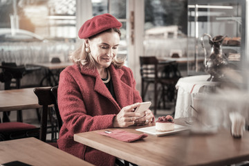 Pretty senior woman sitting in cafe alone