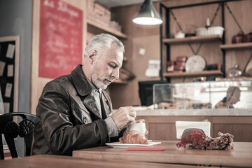 Cheerful senior male person visiting favorite cafe