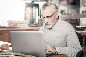 Attentive mature man checking his email in internet