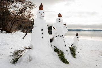Schneemann Familie am Lake Tahoe im Winter mit Schnee am Strand, Kalifornien, USA
